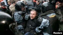 Московская полиция задерживает правозащитника Льва Пономарева во время акции протеста российской оппозиции. Архивное фото.