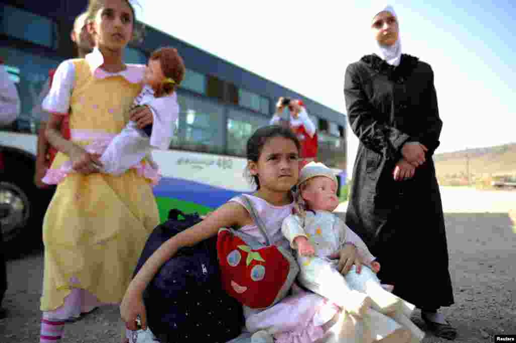 Anak-anak perempuan yang dievakuasi dari Daraya, pinggiran kota Damaskus, tiba di kamp pengungsi yang dikelola pemerintah di Herjalleh, juga di pinggiran Damaskus (27/8). (Reuters/Omar Sanadiki)