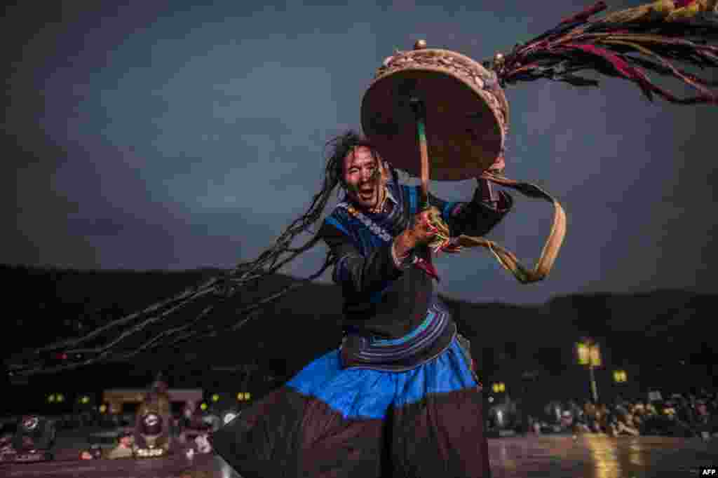Seorang dukun berpakaian tradisional suku Yi tampil pada festival di Xichang, Sichuan, China.