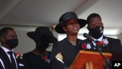 La ex primera dama de Haití, Martine Moïse, habla durante el funeral de su esposo asesinado, el ex presidente Jovenel Moïse, acompañada de sus hijos en Cabo Haitiani, Haití, el viernes 23 de julio de 2021.