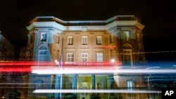 ARCHIVO - Rayas de tráfico se reflejan frente a la embajada de Cuba en Washington la madrugada del sábado 26 de noviembre de 2016.