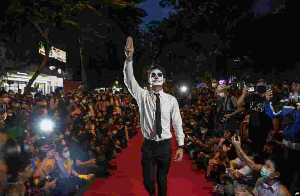 Pro-democracy protesters perform on a mock "red carpet" fashion show billed as a counterpoint to a fashion show being held by one of the monarchy's princesses nearby in Bangkok, Thailand.