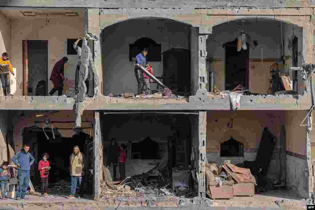 Palestinian men check the debris at a building, following overnight Israeli airstrikes in Rafah refugee camp in the southern Gaza Strip, amid continuing battles between Israel and the Palestinian militant group Hamas. 
