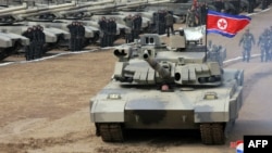 Esta fotografía tomada el 13 de marzo de 2024 y publicada al día siguiente por la agencia oficial de noticias de Corea del Norte, KCNA, muestra al líder norcoreano Kim Jong Un conduciendo un tanque.
