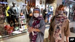 Women wearing protective face masks and gloves to help prevent the spread of the coronavirus shop at the Kourosh Shopping Center in Tehran, Iran, Monday, April 20, 2020. 