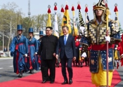 North Korean leader Kim Jong Un, left, and South Korean President Moon Jae-in walk together at the border village of Panmunjom in the Demilitarized Zone, April 27, 2018.
