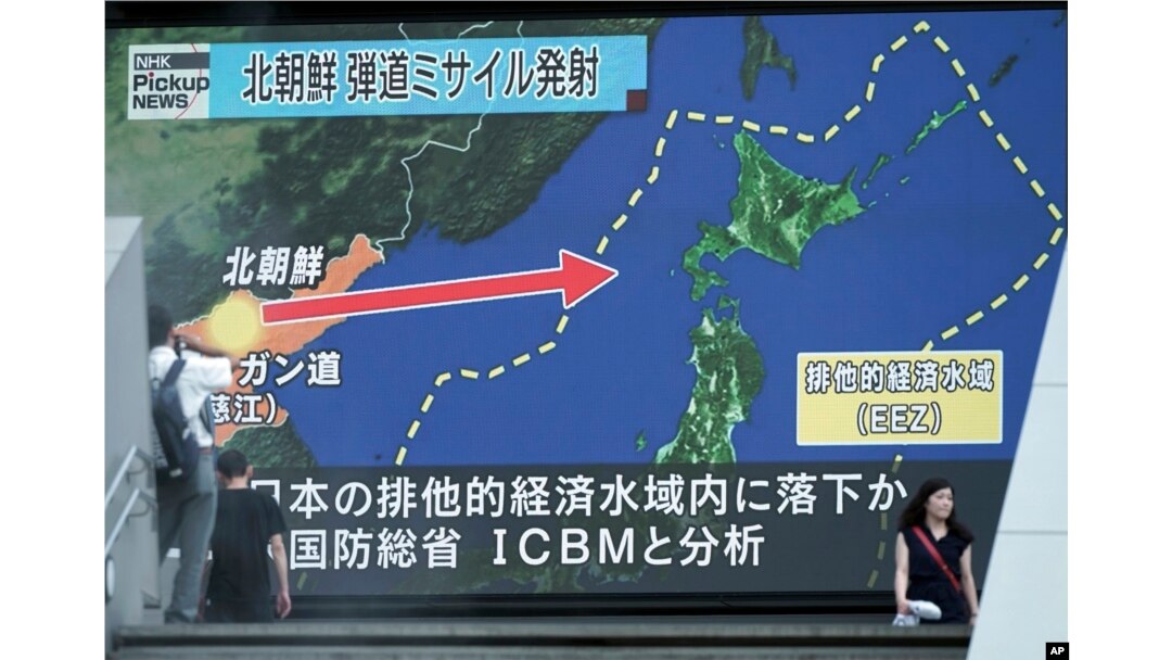 FILE - People walk past a public TV screen broadcasting news of North Korea's launch of its second intercontinental ballistic missile, in Tokyo, July 29, 2017.