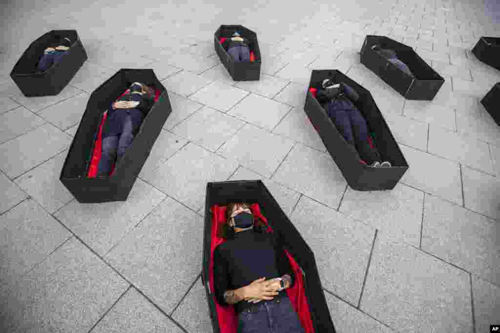 Women laying in coffins representing those killed in domestic violence during an event for upcoming International Women's Day in front of Tel Aviv's district court, Israel.