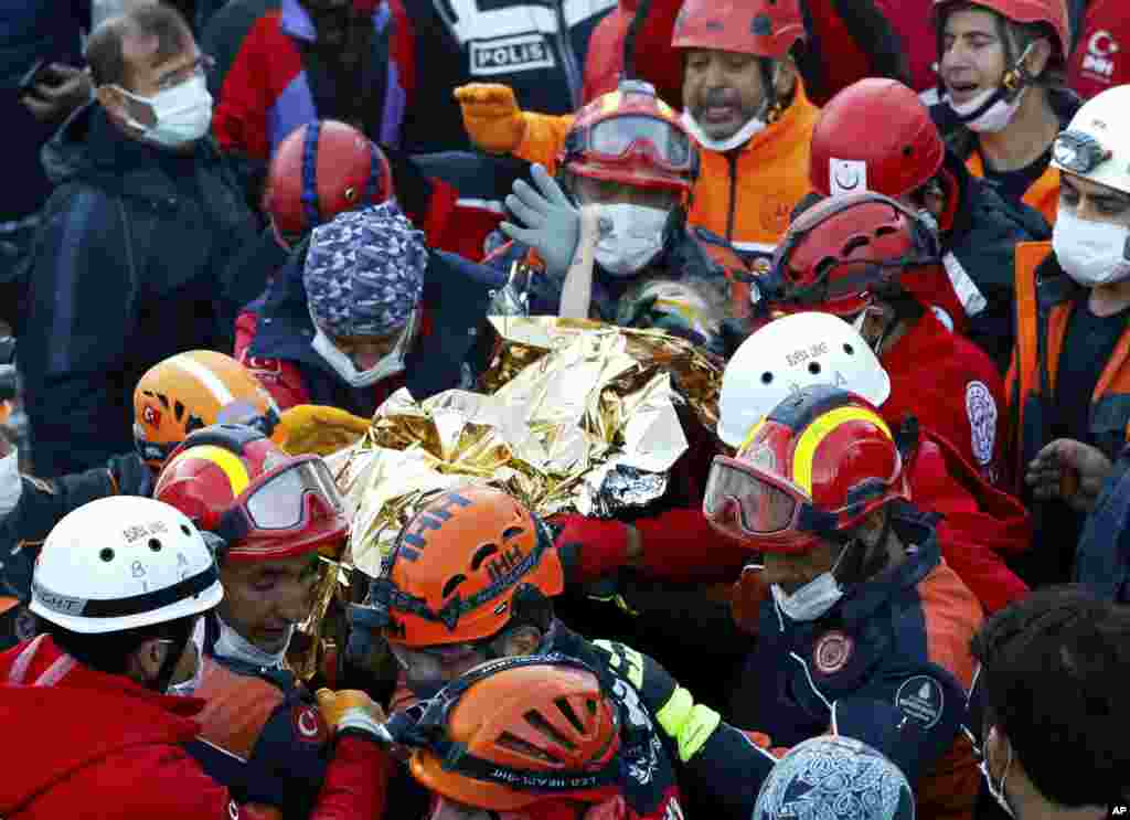 Elif Perincek, a three-year-old survivor, holds the thumb of a rescue worker as she is rescued from the rubble of a building some 65 hours after a magnitude 6.6 earthquake in Izmir, Turkey. (Istanbul Fire Authority/Handout)