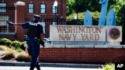 Un oficial armado aleja a un vehículo de la entrada al Astillero Naval de Washington. La Armada fue advertida de los problemas mentales del atacante.