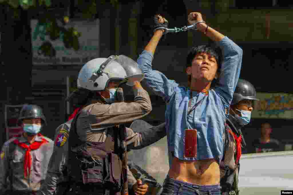 A pro-democracy protester is detained by riot police during a rally against the military coup in Yangon, Myanmar, Feb. 27, 2021.
