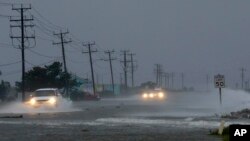 Kendaraan menembus banjir akibat angin Badai Arthur yang mendorong air ke jalanan di Nags Head, North Carolina (4/7).