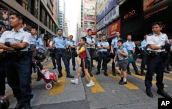 Học sinh băng ngang đoạn đường bị chiếm đóng ở khu Mong Kok, Hong Kong, để đến trường ngày 17/10/2014.