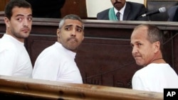 Ký giả người Canada Mohamed Fahmy (giữa), ký giả Baher Mohamed, người Ai Cập, và ký giả người Úc Peter Greste tại tòa án ở Cairo.