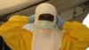 A health worker adjusts protective gear at a Doctors Without Borders' Ebola treatment unit in Conakry, Guinea. (VOA / Carol Guensburg) 
