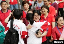 지난 7일 중국 베이징에서 '가오카오' 대입시험을 치기 위해 수험장에 온 학생을 교사들이 격려하고 있다.