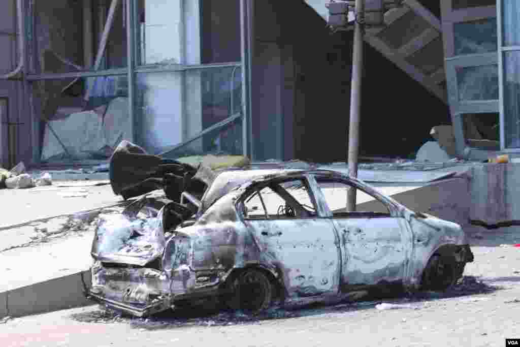 天津爆炸事故現場,核心爆炸區週圍多座居民樓窗戶被震碎,高速公路橋樑受損,多輛大貨車被炸翻,小汽車起火或被砸,多名當地居民仍逗留在事故現場。(美國之音記者東方拍攝)