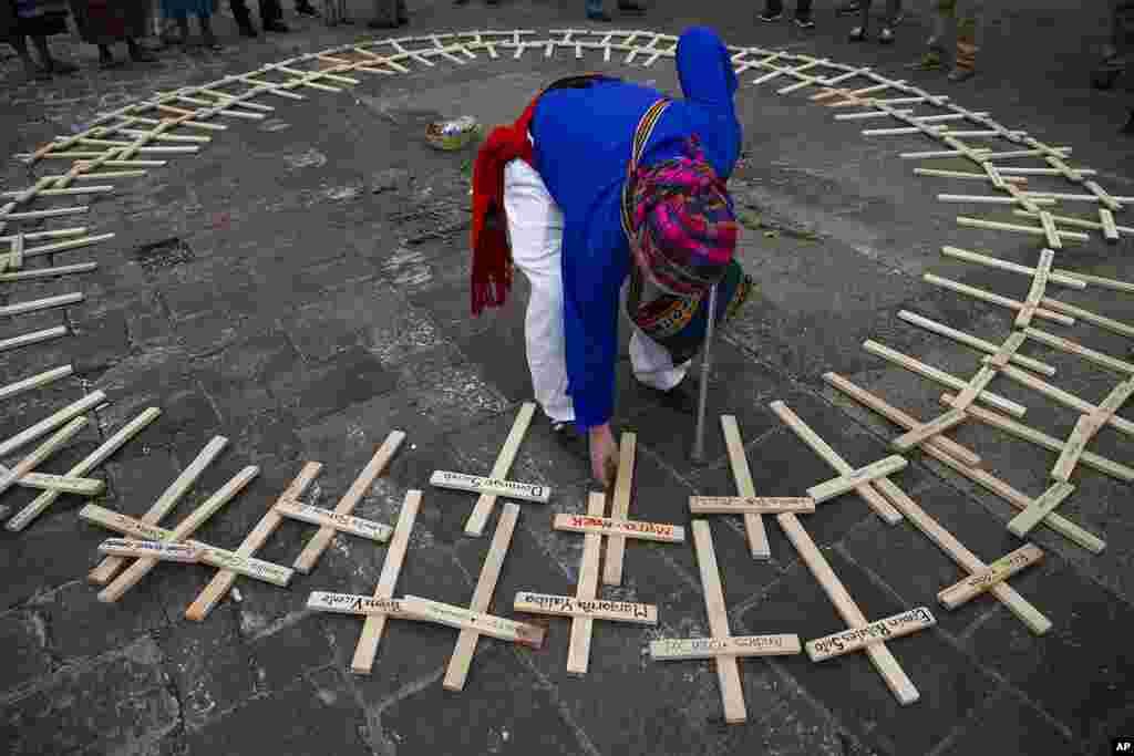 A Mayan spiritual guide arranges crosses with the names of people who died in the nation's civil war, which ended in 1996, in a circle for a ceremony marking National Day of Dignity for the Victims of Armed Internal Conflict, at the National Palace in Gua
