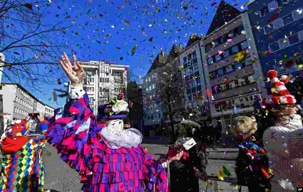 Just a few people in costumes come together at the "Alter Markt" where normally tens of thousands of revelers dressed in carnival costumes would celebrate the start of the street carnival in Cologne, Germany.