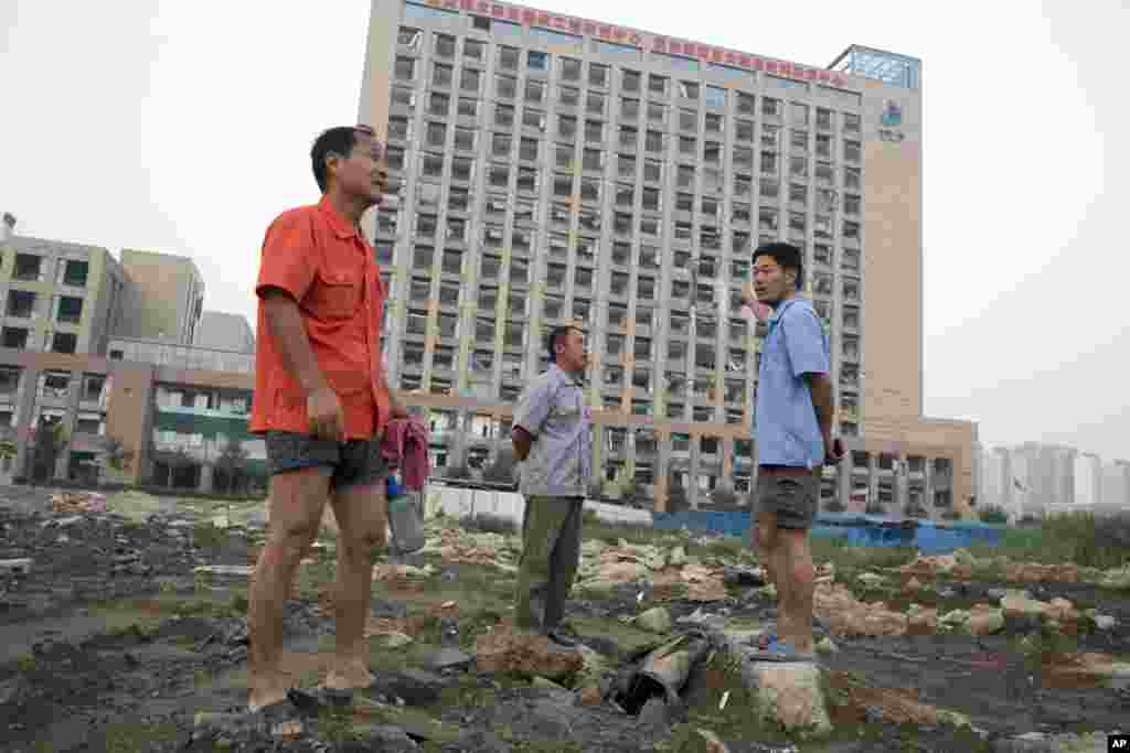 工人走過受損的大樓: 爆炸衝擊波震碎的窗戶