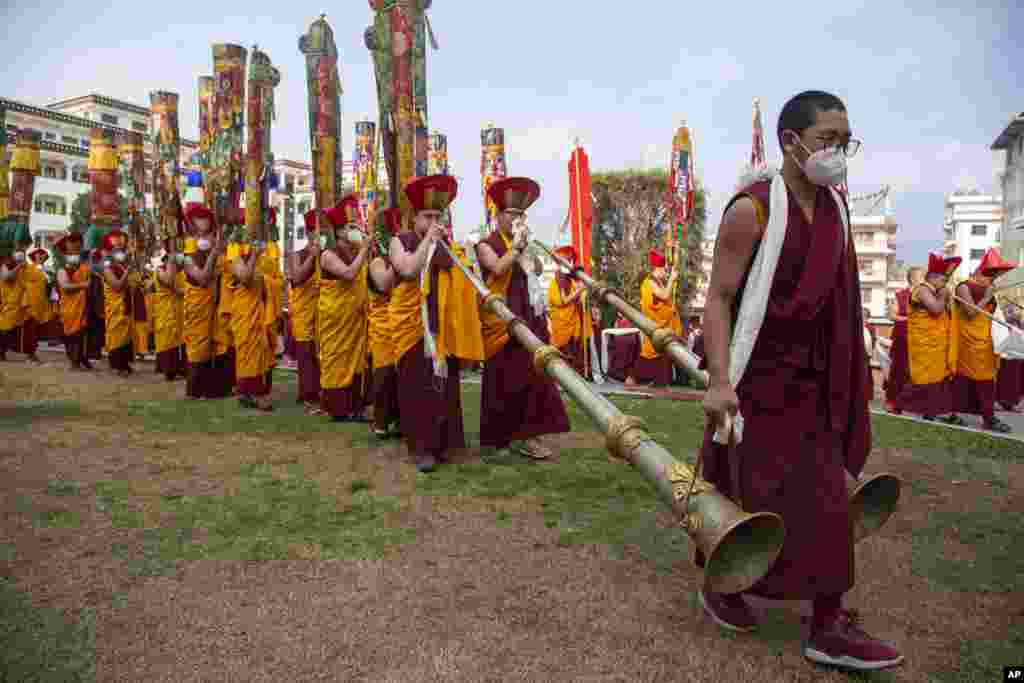 Nepalese Buddhist monks play traditional instruments during a procession after the body of Tsikey Chokling Rinpoche arrived at the Ka-Nying Shedrub Ling monastery in Kathmandu.
