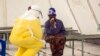 A health worker wearing protective gear attends to a newly admitted suspected Ebola patient in a quarantine zone at a Red Cross facility in the town of Koidu, Kono district in Eastern Sierra Leone, Dec. 19, 2014. 