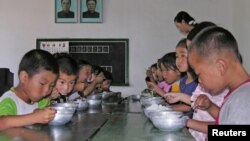 Trẻ em Bắc Triều Tiên ăn trưa tại trường mẫu giáo nhà nước ở quận Taedong, ở phía nam tỉnh Pyongan, Bắc Triều Tiên, ngày 18/7/2005.