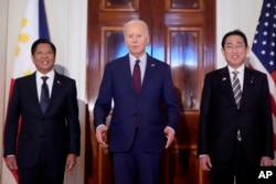 El presidente Joe Biden habla junto al presidente filipino Ferdinand Marcos Jr., (izq) y el primer ministro japonés, Fumio Kishida, antes de una reunión trilateral en el Salón Este de la Casa Blanca en Washington, el jueves 11 de abril de 2024. (Foto AP/Mark Schiefelbein )