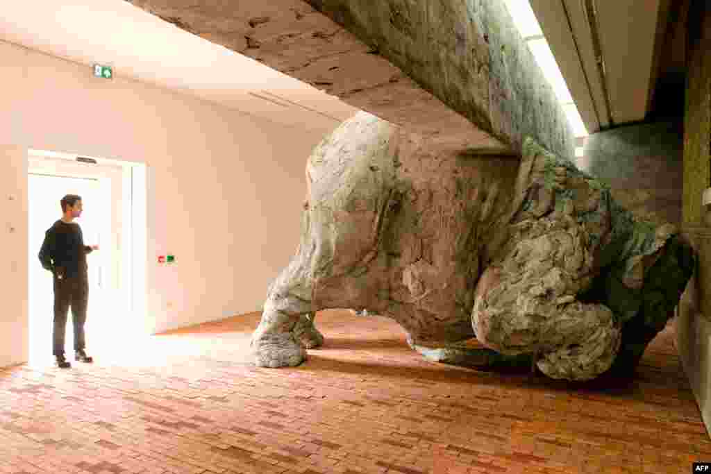 A member of the staff looks at one of the items in Adrian Villar Rojas' "Today We Reboot The Planet" exhibition at the Serpentine Sackler Gallery of the Serpentine Sackler Gallery in London. 