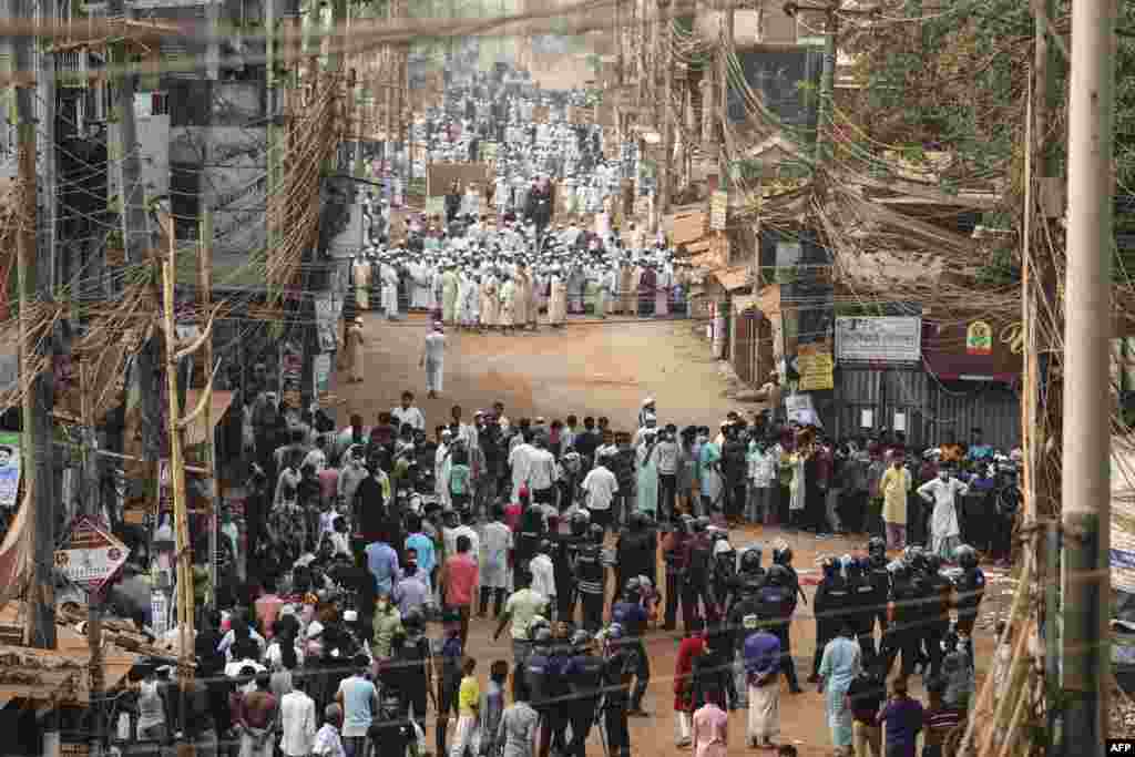 Activists of the Hifazat-e Islam group clash with police, in foreground, in Chittagong during a demonstration against Indian Prime minister Narendra Modi's visit to Bangladesh.