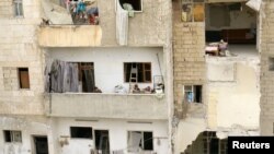 Children stand on a balcony of a damaged building at a site hit at dawn by an airstrike in the rebel-controlled town of Ariha in Idlib province, Syria, Feb. 27, 2017.