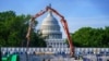 FILE - A concrete pump frames the Capitol Dome during renovations and repairs to Lower Senate Park on Capitol Hill in Washington, May 18, 2021.