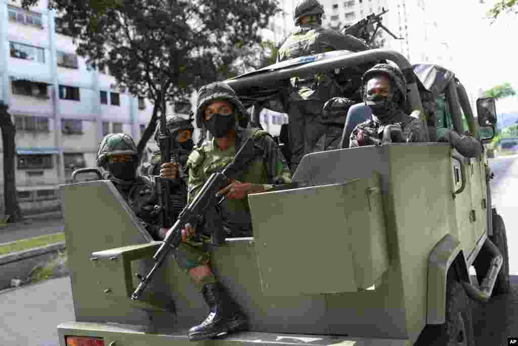 Soldiers patrol on a military vehicle during elections to choose members of the National Assembly in Caracas, Venezuela. The vote, championed by President Nicolas Maduro, is rejected as fraud by the nation's most influential opposition politicians.