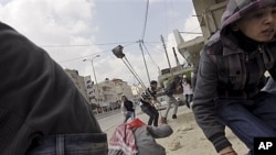 Người Palestine ném đá vào binh sĩ Israel ở chốt kiểm soát Kalandiam, nằm giữa Jerusalem và thành phố Ramallah ở bờ Tây, 30/3/12
