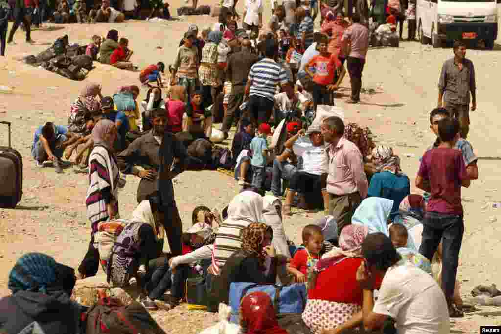 Para pengungsi Suriah menunggu melintasi perbatasan menuju daerah otonom Kurdi di Irak utara (21/8). Pemerintah Kurdistan membatasi kuota 3.000 orang sehari untuk membatasi arus pengungsi.