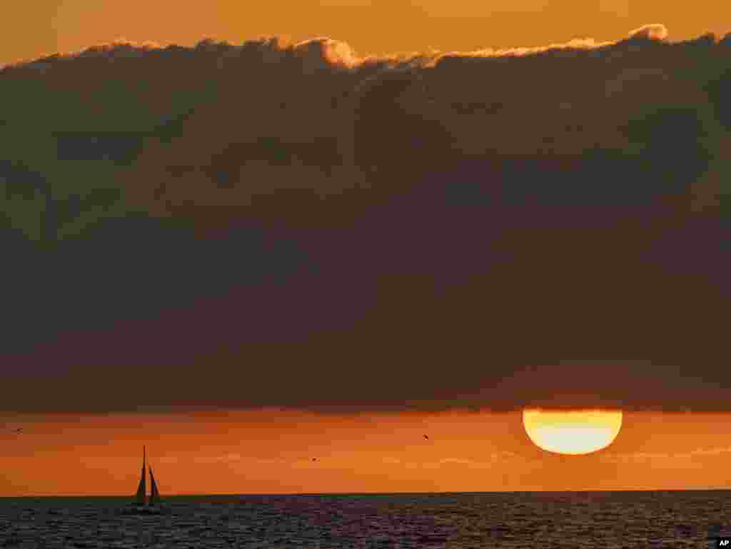 A sailboat glides on the Pacific Ocean off the coast of Venice Beach during sunset in Los Angeles, California, Dec. 27, 2020. Southern California's first significant storm of the season is expected to bring rain and snow to the region Sunday night through Monday, according to the National Weather Service.