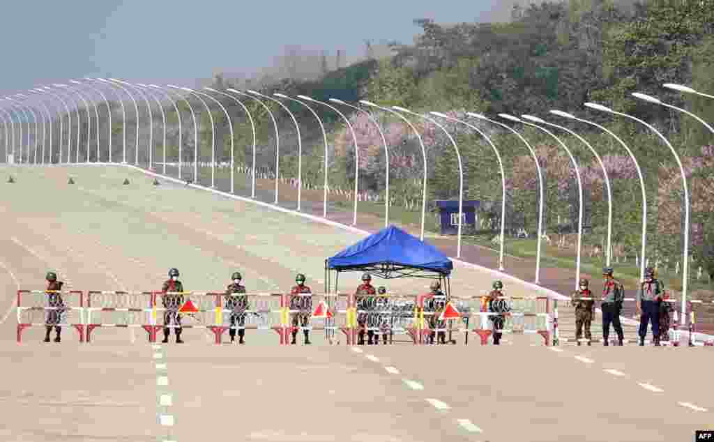 Soldiers stand guard on a blockaded road to Myanmar's parliament in Naypyidaw after the military detained the country's de facto leader Aung San Suu Kyi and the country's president in a coup.