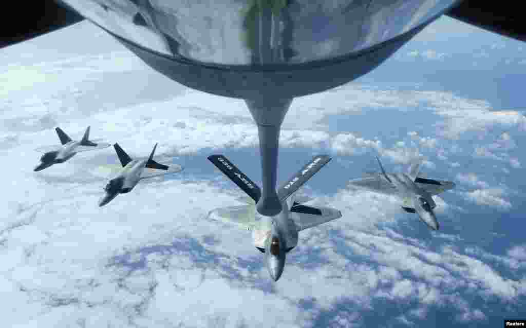 Four F-22 Raptors fly in formation after a mid-air refueling exercise with a KC-135R Stratotanker as they participate in the multi-national military exercise RIMPAC in Honolulu, Hawaii, July 26, 2016.