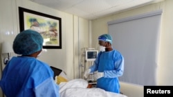 FILE - Doctor Oluwajoba Oroge attends to a patient at EHA Clinics in Abuja, Nigeria, Jan. 14, 2021. Picture taken, Jan, 14, 2021. 