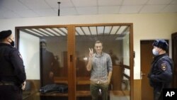 El líder opositor ruso Alexei Navalny saluda desde la corte de Babuskinsky, en Moscú, el 20 de febrero de 2021