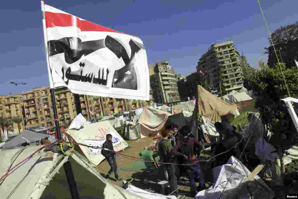 Anti-Morsi protesters sit outside their tents, below a flag that reads, "No, to Constitution," Tahrir Square, Cairo, Egypt, December 10, 2012.