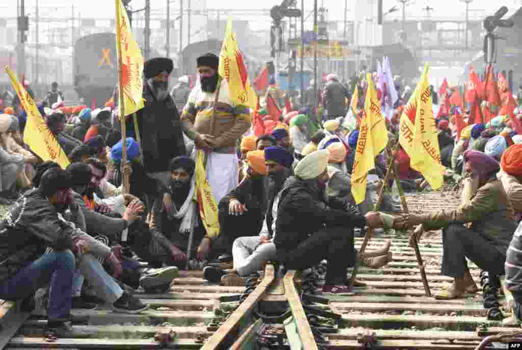Farmers block railway tracks during a four-hour rail blockade as they continue their protest against the central government's recent agricultural reforms, at a railway station in Amritsar, India.