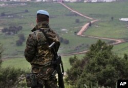 FILE - A U.N. peacekeeper looks to the U.N.-demarcated "Blue Line" border between Lebanon and Israel, Feb. 24, 2015.