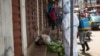 Heath workers collect samples from the body of a person suspected to have died from the Ebola virus, as it lies on the street covered in leaves in Freetown, Sierra Leone, Oct. 8, 2014.