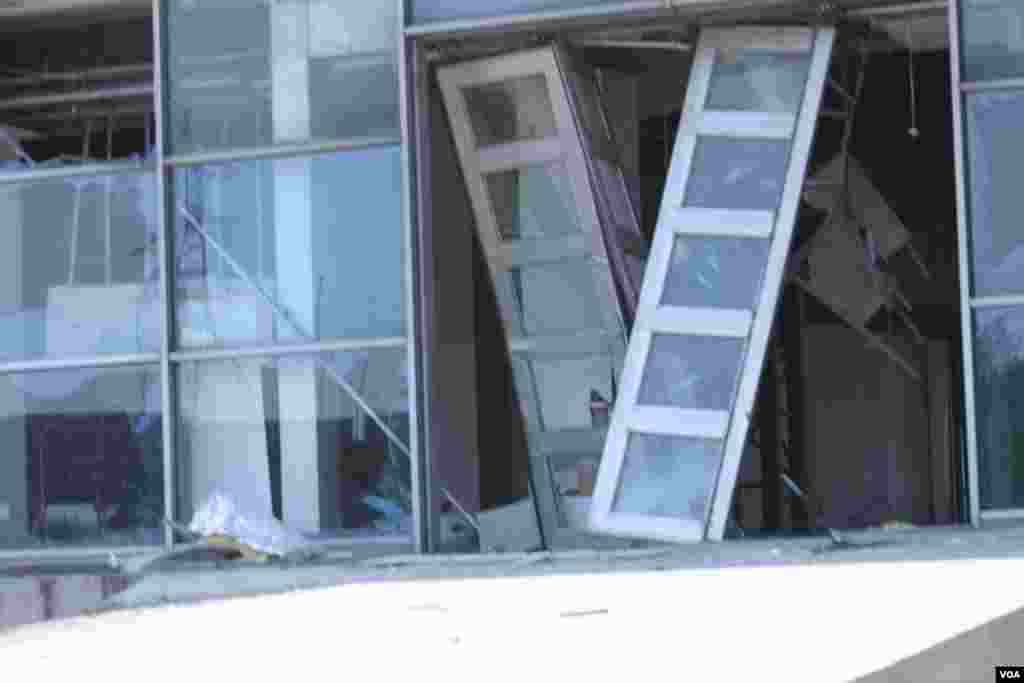 天津爆炸事故現場,核心爆炸區週圍多座居民樓窗戶被震碎,高速公路橋樑受損,多輛大貨車被炸翻,小汽車起火或被砸,多名當地居民仍逗留在事故現場。(美國之音記者東方拍攝)