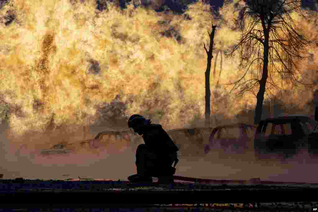 A firefighter works to extinguish a fire of a gas pipe line damaged by a Russian rocket attack, in Kyiv, Ukraine. Russia pounded the capital Kyiv and the northeastern city of Kharkiv in a new wave of heavy airstrikes, killing at least five civilians, wounding dozens of people, causing widespread damage and hitting power supplies, officials said.