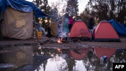 Un niño se calienta en una fogata de un campamento de solicitantes de asilo mexicanos en el Parque Chamizal, cerca del Puente de las Américas en Ciudad Juárez, México, el 13 de diciembre de 2019. 