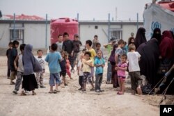 Perempuan dan anak-anak berkumpul di depan tenda mereka di kamp al-Hol yang menampung sekitar 60.000 pengungsi di provinsi Hasakeh, Suriah (foto: dok).
