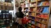 FILE - Paula Jarvis, 61, buys biscuits at the King's Head pub in Santa Monica, California, May 6, 2021. Prices Americans pay for goods and services are rising at the fastest rate in more than a decade.