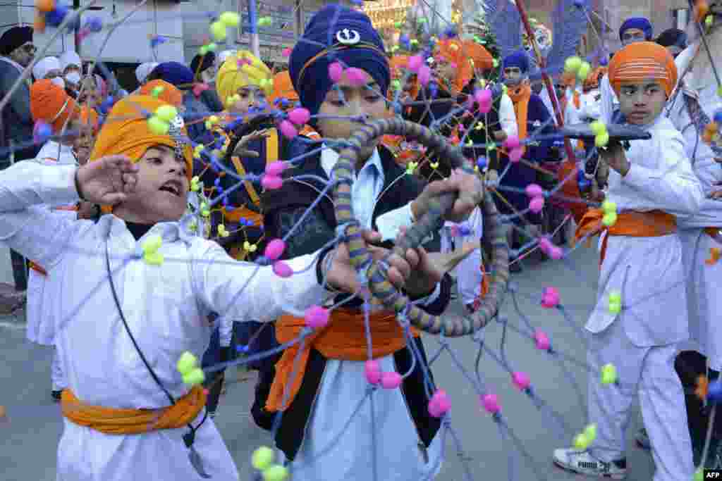 Sikh youth perform "Gatka," an ancient form of Sikh martial arts, during a religious procession on the eve of martyrdom day of the ninth Sikh Guru Tegh Bahadur in Amritsar, India.